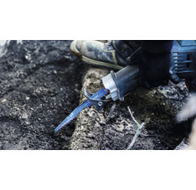 Eine Person benutzt eine Säbelsäge zum Schneiden von Holz.