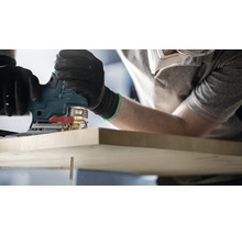 Eine Stichsäge wird zum Sägen eines Holzstücks verwendet.