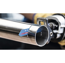 Eine Metallsäge schneidet ein Metallrohr.