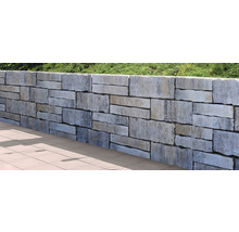 Mauer aus Steinblöcken im Garten