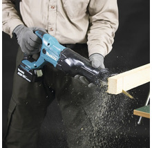 Eine Person sägt mit einer Akku-Säbelsäge ein Holzbrett.