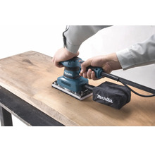 Makita Schwingschleifer in Gebrauch auf Holzoberfläche