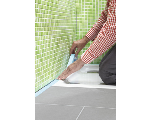 Handwerker dichtet Duschwanne mit Dichtband im Badezimmer ab.