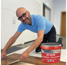 Mann verlegt Boden mit Universalkleber AF 2224 von Ardex