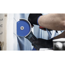 Eine Person schneidet mit einem Winkelschleifer eine Trockenbauwand.