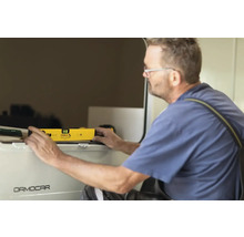 Ein Mann benutzt eine Wasserwaage an einem Schrank