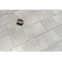 Graue Pflastersteine im Verband verlegt mit Dekoration