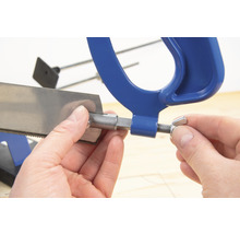 Detailaufnahme einer Metallsäge, die von einer Hand fixiert wird