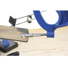 Metallsäge mit blauem Griff auf einem Holztisch