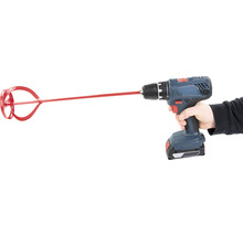 Eine Bohrmaschine mit einem Farbmischer wird von einer Hand gehalten.