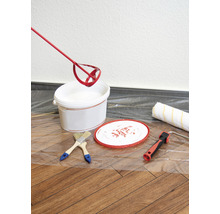 Farbeimer, Farbrührer, Pinsel und Farbroller auf einer Schutzfolie für Malerarbeiten