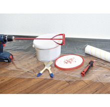 Farbeimer, Rührgerät, Bohrmaschine, Farbroller und Pinsel auf einer Folie
