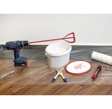 Szene mit Bohrmaschine, Farbmischer, Farbeimer, Pinsel und Farbroller auf einer Schutzfolie