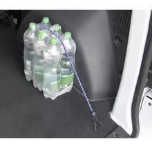 Eine Packung Mineralwasser ist mit einem Spanngurt im Kofferraum eines Autos gesichert.