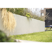 Beton-Pflanzkasten im Garten mit Gras und Pflanzen