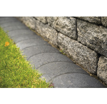 Steinmauer mit Rasenfläche und gepflastertem Weg