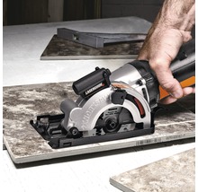 Handgeführte Säge mit Laserführung schneidet eine Fliese