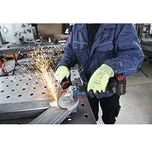 Eine Person benutzt einen Akku-Winkelschleifer zum Schneiden von Metall, wobei Funken fliegen.