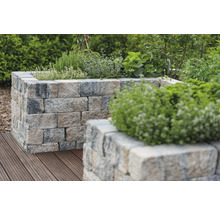 Hochbeet aus Steinblöcken mit Bepflanzung im Garten