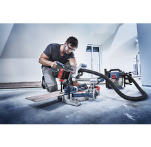 Handwerker bei der Arbeit mit einer Kapp- und Gehrungssäge in einem Raum.