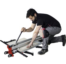 Mann schneidet Fliesen mit Fliesenschneider