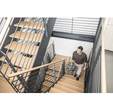 Mann trägt einen Mehrzwecksauger eine Treppe hinauf