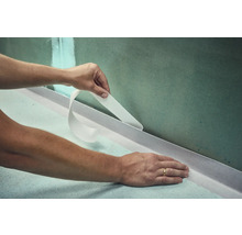 Anwendung von Dichtband im Badezimmer zur Abdichtung von Wand und Boden.