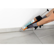 Anwendung von Dichtmasse mit Kartuschenpistole auf einer Fliesenfuge