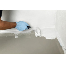 Auftragen einer Dichtungsschlämme mit einer Farbwalze im Innenbereich