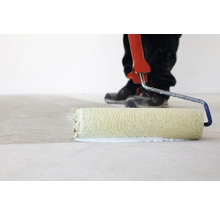 Farbe wird mit einer Farbwalze auf einen Boden aufgetragen.