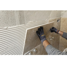 Fliesenleger bei der Arbeit: Anbringen von Wandfliesen im Badezimmer