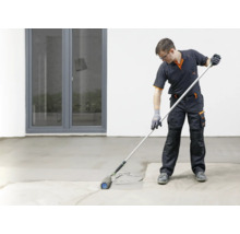 Handwerker versiegelt Boden mit Farbroller und Teleskopstiel