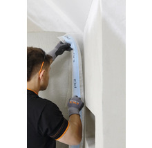 Handwerker befestigt Dichtband von PCI in einer Ecke