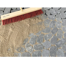 Pflasterfugen werden mit einem Besen und Fugensand verfüllt.