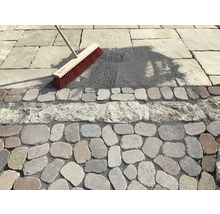 Szene einer Pflasterfugenreinigung mit einem Besen