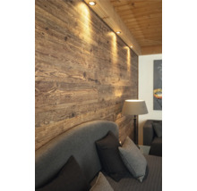 Schlafzimmer mit Holzwand und Beleuchtung