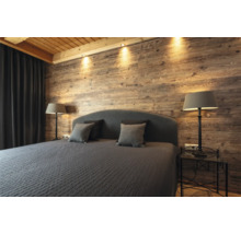 Schlafzimmer mit Holzwand, Bett, Nachttischen und Lampen