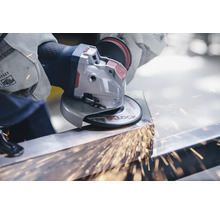 Anwender schleift Metall mit einem Winkelschleifer, Funken fliegen