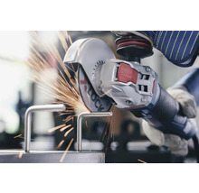 Eine Person, die mit einem Winkelschleifer ein Metallstück bearbeitet, wobei Funken sprühen.