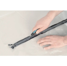 Person schneidet Dichtband mit Cuttermesser zu