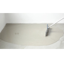 Ausgleichsmasse wird mit einer Rakel auf dem Boden verteilt.