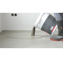 Ausgießen von Bodenausgleichsmasse aus einem Eimer zur Egalisierung