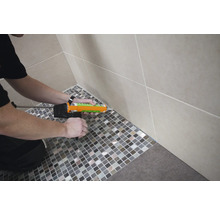 Verfugen von Mosaikfliesen im Badezimmer mit Dichtstoffpistole