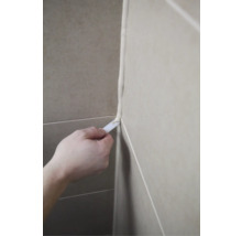 Eine Person glättet eine Fuge mit einem Werkzeug.