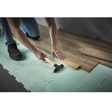 Verlegen von Laminat mit Hammer und Schlagholz auf Dämmunterlage
