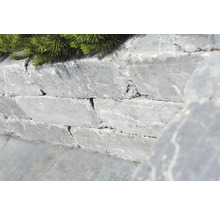 Mauer aus Natursteinen mit grüner Bepflanzung