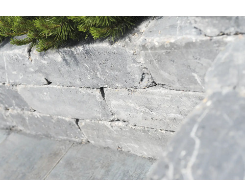 Mauer aus Natursteinen mit grüner Bepflanzung