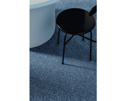 Detailansicht eines blauen Teppichs mit einem runden Tisch und einem schwarzen Stuhl.