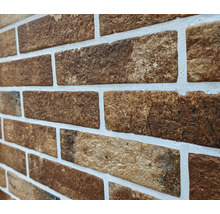 Nahaufnahme einer Wand mit braunen Ziegeln und weißen Fugen