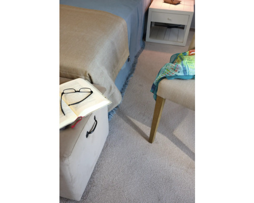 Detailaufnahme eines Schlafzimmers mit Bett, Teppich und Möbeln